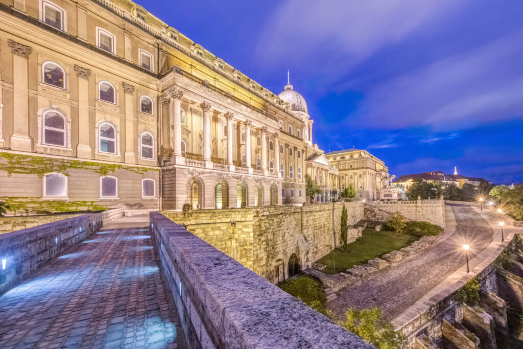 A budapesti Királyi Palota alkonyatkor megvilágított, lenyűgöző építészettel és élénk világítással.