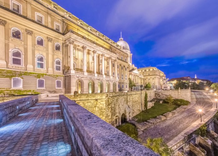 A budapesti Királyi Palota alkonyatkor megvilágított, lenyűgöző építészettel és élénk világítással.