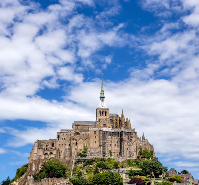 Mont Saint-Michel Abbey | Fortified Island in France Mont Saint-Michel, a medieval abbey and fortified island, rising dramatically from the landscape under a sky with dramatic clouds in France.